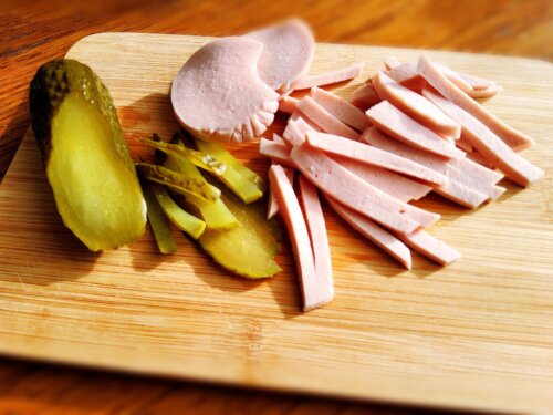 нарізана варена ковбаса кубиками на обробній дошці